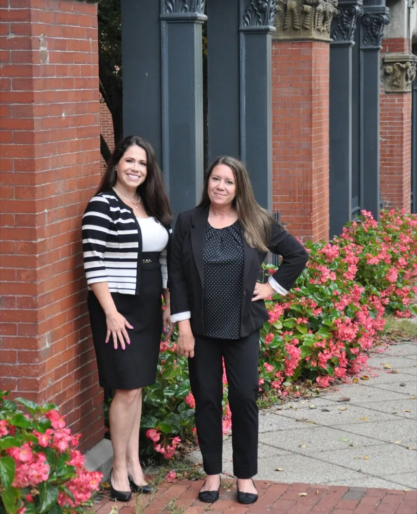 Attorneys Dawn M. Kelliher and Megan E. Beyer standing outside a historic building in Massachusetts